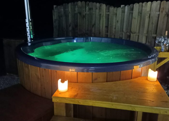 La bain nordique de nuit, l'eau éclairée en vert et une petite lampe