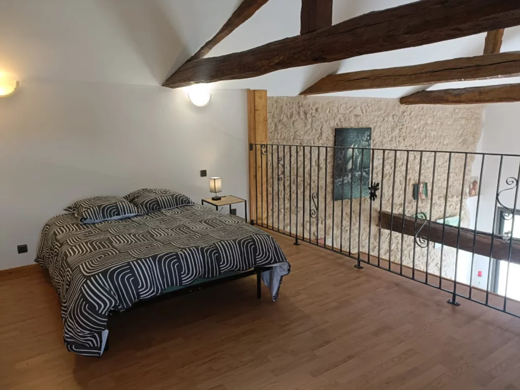 Logement - Gîte Le lit double de la chambre mezzanine avec vue sur le salon