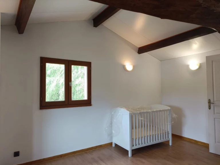 La chambre mezzanine prise depuis le lit, vue sur le lit bébé et le fauteuil