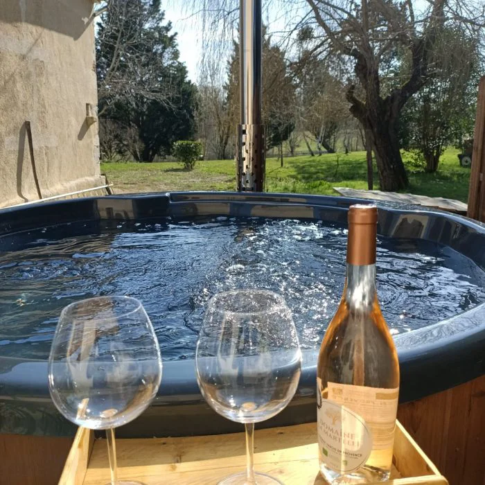 Le spa extérieur avec deux verres de vin rosé