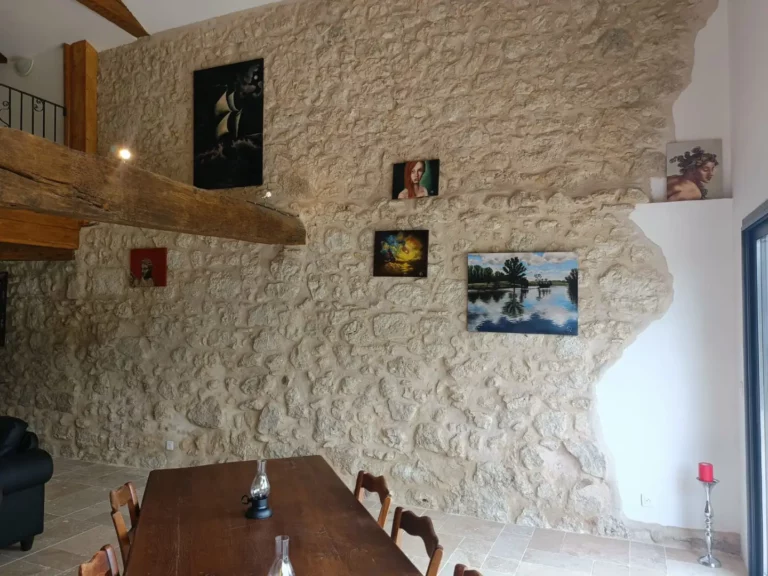 La table du salon face au mur en pleines pierres